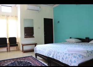 a bedroom with a bed and a blue wall at Hotel Third Eye in Pushkar
