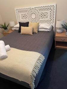 ein großes Bett mit einem weißen Kopfteil und Kissen in der Unterkunft Federal Hotel in Quirindi