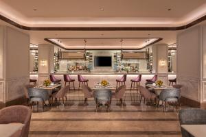 a restaurant with tables and chairs and a bar at Aurika, Mumbai International Airport - Luxury by Lemon Tree Hotels in Mumbai