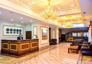un hombre de pie en un bar en el vestíbulo de un hotel en Grand Hotel Eurasia, en Almaty