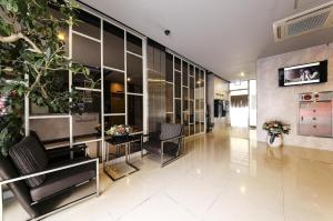 a lobby with chairs and a plant in a building at Wate Hotel in Yeosu