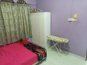 a bedroom with a bed and a curtain and a chair at Saffira Homestay Near Universiti Malaya Education Centre -UMEC in Bachok