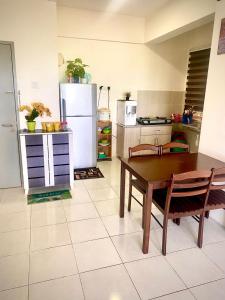 uma cozinha com uma mesa e um frigorífico em Mk guesthouse em Kuantan