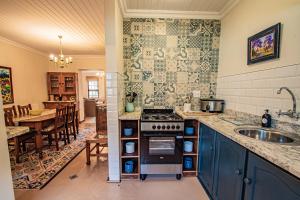 cocina con fregadero y fogones horno superior en Crossroads Cottage, en Dullstroom