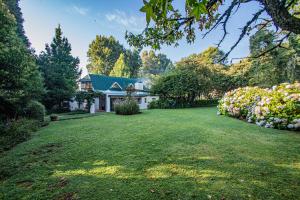 una casa con un gran patio con flores en Crossroads Cottage, en Dullstroom