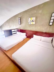 two beds in a large room with at Big Hotel in Cebu City