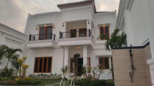 Casa blanca con balcón en la parte superior. en Fernasya House 2, en Yogyakarta