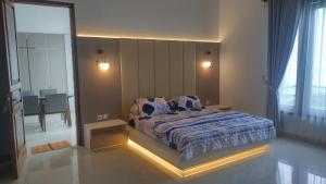 Un dormitorio con una cama grande con luces. en Fernasya House 2, en Yogyakarta