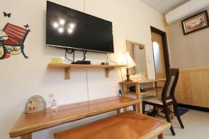 大內區的住宿－556吉荷民宿 ，客厅的墙上配有平面电视。