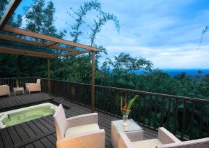 a deck with chairs and a hot tub on top at The Tamara Coorg in Kakkabe