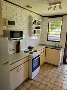 una cocina con estufa y refrigerador en Kalbarri Reef Villa 2, en Kalbarri