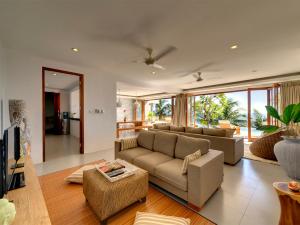ein Wohnzimmer mit einem Sofa und einem Tisch in der Unterkunft Malimbu Cliff Villa by Elite Havens in Senggigi 
