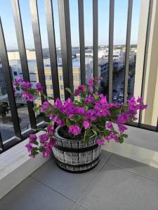 a pot of purple flowers sitting on a window sill at Saint Honore Executive 1 Full bed, 1 Sofa bed 1 Pull out bed 2BR in Iloilo City