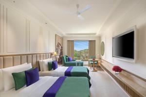 a hotel room with two beds and a flat screen tv at Aurika, Mumbai Skycity - Luxury by Lemon Tree Hotels in Mumbai