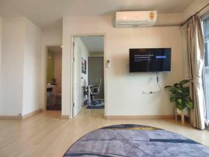 uma sala de estar com televisão na parede em Central Comfy Airy Tidy Apartment em Udon Thani