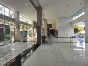 un gran vestíbulo con suelo de cristal y mesa en Central Comfy Airy Tidy Apartment en Udon Thani