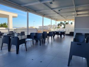 a dining room with tables and chairs and windows at Hotel Natursun in Torremolinos