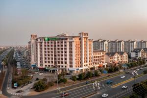 a large building on a city street with traffic at Holiday Inn Express Zhangjiagang Free Trade Zone, an IHG Hotel in Zhangjiagang