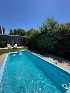 a swimming pool with blue water in a yard at Departamento La Delfina in Ciudad Lujan de Cuyo