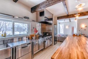 a kitchen with stainless steel appliances and a wooden floor at Gensei in Niseko