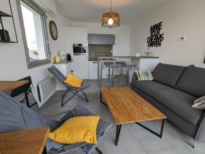 uma sala de estar com um sofá e uma mesa em St Gilles Appartement face mer em Saint-Hilaire-de-Riez