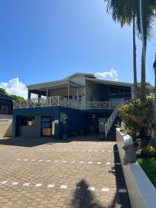 ein blaues Gebäude mit einer Treppe und Palmen in der Unterkunft Whalesong Guest House in St Lucia