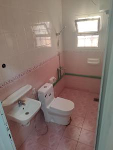 uma casa de banho com um WC branco e um lavatório. em The best room for peace of mind em Mascate