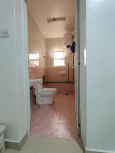 a bathroom with a toilet and a sink and a window at The best room for peace of mind in Muscat