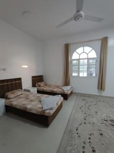 um quarto com 2 camas, uma janela e um tapete em The best room for peace of mind em Mascate