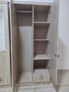 um armário de madeira com prateleiras na casa de banho em The best room for peace of mind em Mascate