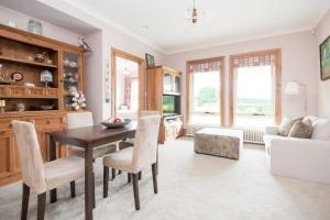 sala de estar con mesa, sillas y sofá en Rural Apartment with Stunning Views, en Relbia