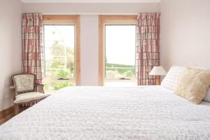 1 dormitorio con 1 cama blanca grande y 1 silla en Rural Apartment with Stunning Views, en Relbia