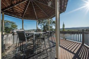 un patio con mesa y sillas en una terraza en Rural Apartment with Stunning Views, en Relbia