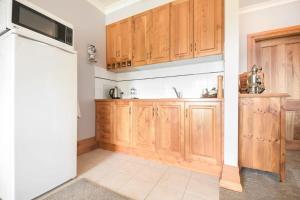 - une cuisine avec des placards en bois et un réfrigérateur dans l'établissement Rural Apartment with Stunning Views, à Relbia