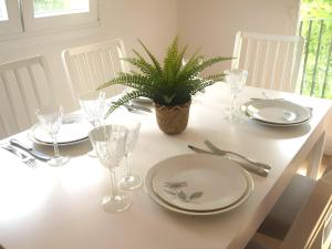 a table with plates and glasses and a plant on it at Jardines del Ebro, 8 Pax, ideal grupos y centrico in Logroño +12 photos
