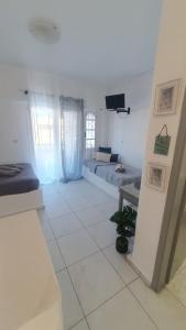 a living room with two beds and a tv at Nikol studio 2 in Kallithea Halkidikis