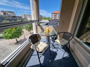 a balcony with two chairs and a table in front of a window at Premier Homes Pori Center Jazz in Pori