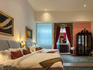a bedroom with two beds and a window at Peranakan Suites Georgetown in George Town +43 photos