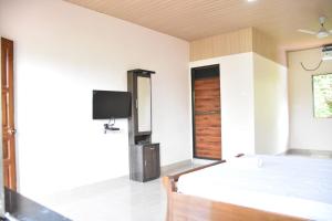 a bedroom with a bed and a tv on the wall at Comforts Stays Kihim in Kīhīm