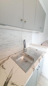 a kitchen counter with a sink and white cabinets at Nikol studio 2 in Kallithea Halkidikis +35 photos