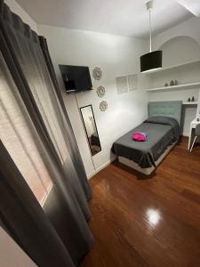 a small bedroom with a bed and a window at Habitaciones Magdalena in Madrid