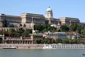 a large building with a boat in the water at Izabella Good Karma Home in Budapest