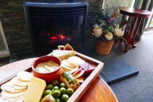 a tray of cheese and fruit on a table with a fireplace at Farmhouse on the Cradle Coast Forth in Forth