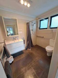 a bathroom with a tub and a toilet and a sink at Farmhouse on the Cradle Coast Forth in Forth