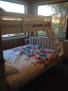 a bedroom with a bunk bed with flowers on it at Farmhouse on the Cradle Coast Forth in Forth