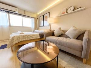 Ban Bang PhangにあるBetter Room ห้องพักรายวัน เมืองทองธานี C4のソファとテーブルのあるリビングルーム