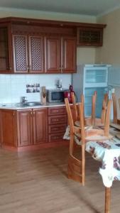 a kitchen with wooden cabinets and a table and chairs at Зона Отдыха Тихий Залив in Topar