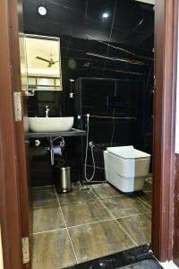 a bathroom with a white toilet and a sink at The Mallika Sapphire in Chikmagalūr