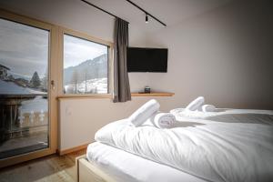 a bedroom with two beds and a large window at WOLF Apartments Padaun in Vals