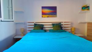a bedroom with a blue bed with two pillows at Villa Bettina 2nd floor in Afionas